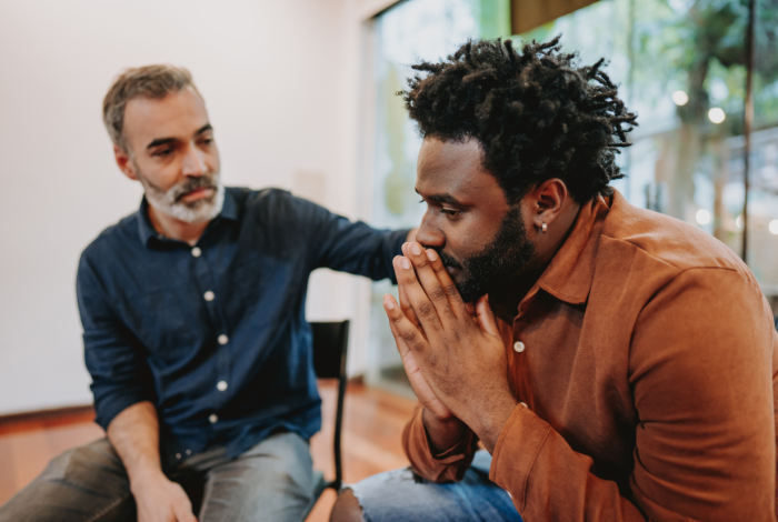 A man offering support to another man