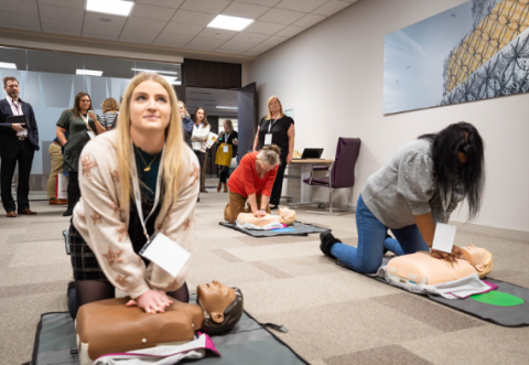Two young women giving CPR to manikins at RCUK conference