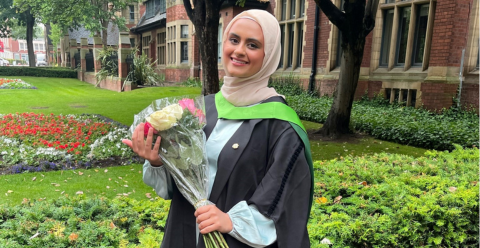 Amirah at her University graduation holding flowers