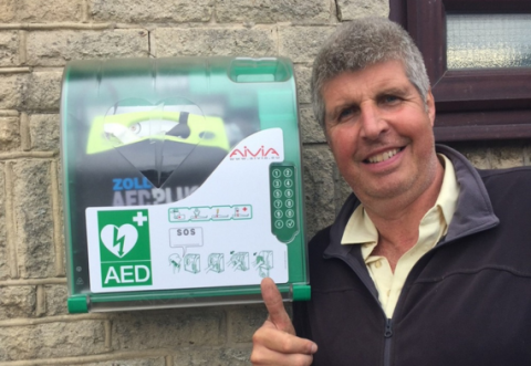 Neil next to a defib